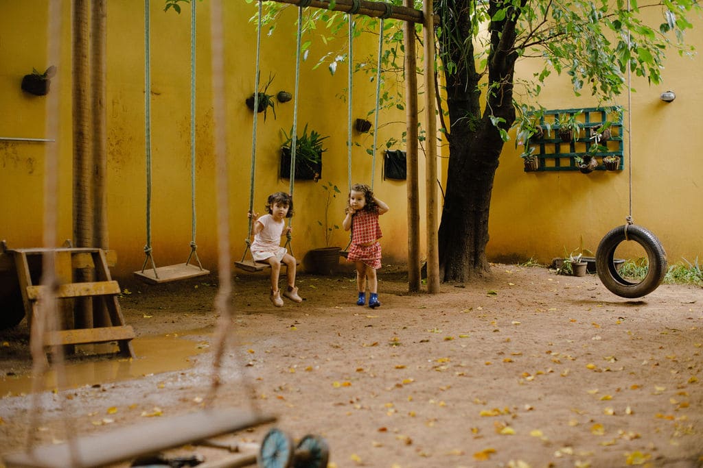 Crianças no pátio da escola brincando com o balanço